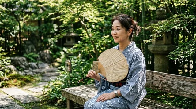 屋外でうちわで扇ぐ人